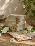 Golden Jasmine Face + Body Bar stacked with jasmine blossoms